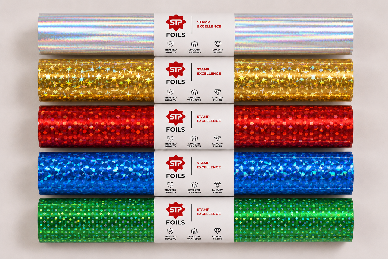 Arrangement of STP Foils holographic foil rolls in gold and silver rainbow patterns.